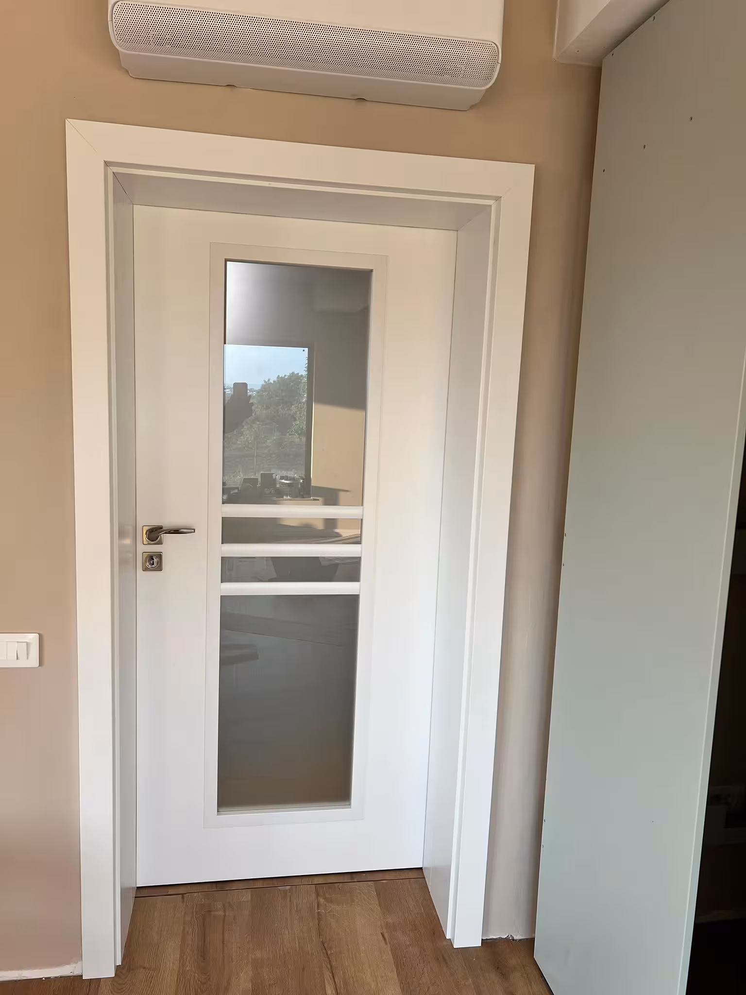 Montaj ușă albă modernă cu panou de sticlă mată, instalată precis într-o locuință din Iași