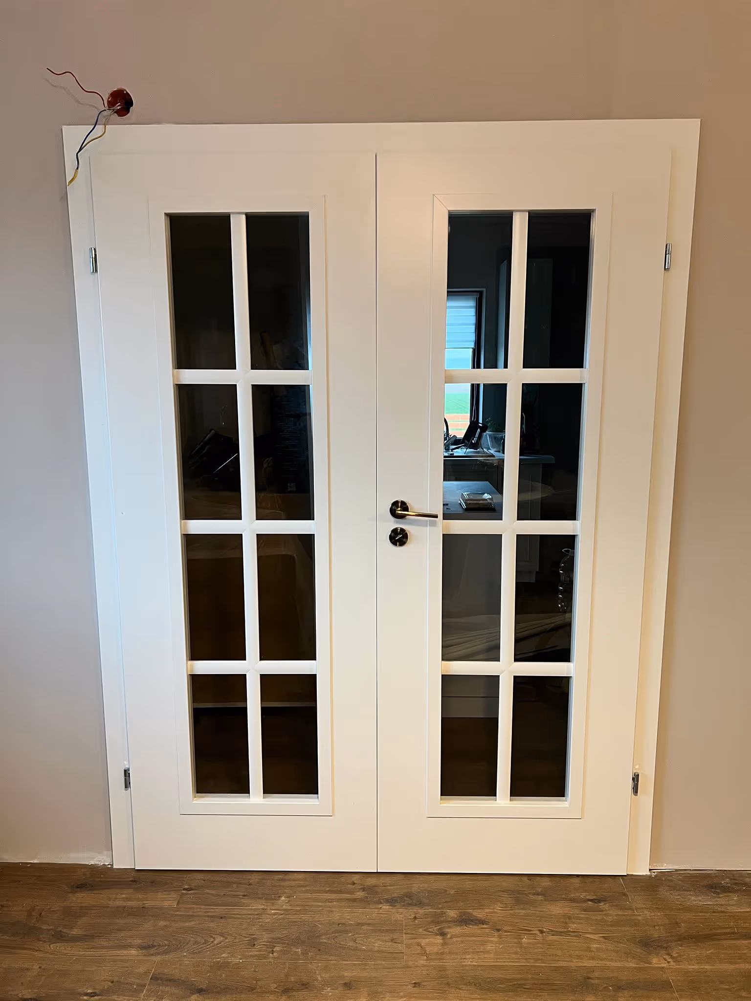 Montaj profesional de ușă dublă albă cu geamuri, instalată corect și finisată estetic într-o locuință modernă