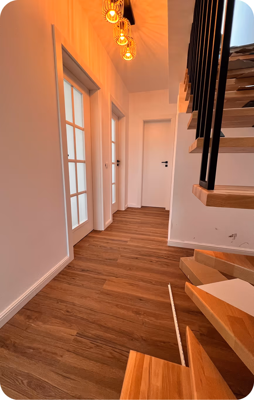 Montaj profesional de uși albe de interior, parchet laminat și plinte din MDF într-un hol modern