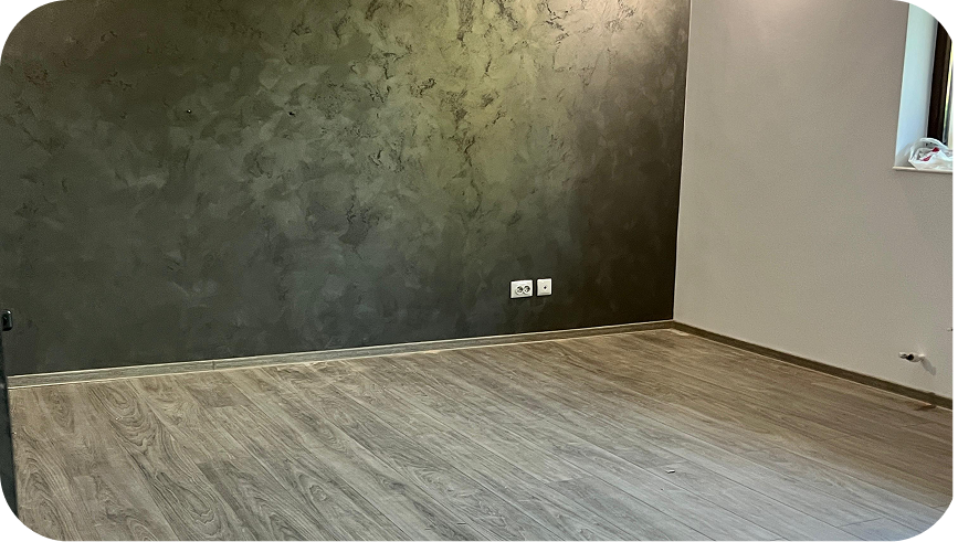 Montaj precis de plinte MDF și parchet laminat într-o cameră modernă cu perete decorativ gri în Iași